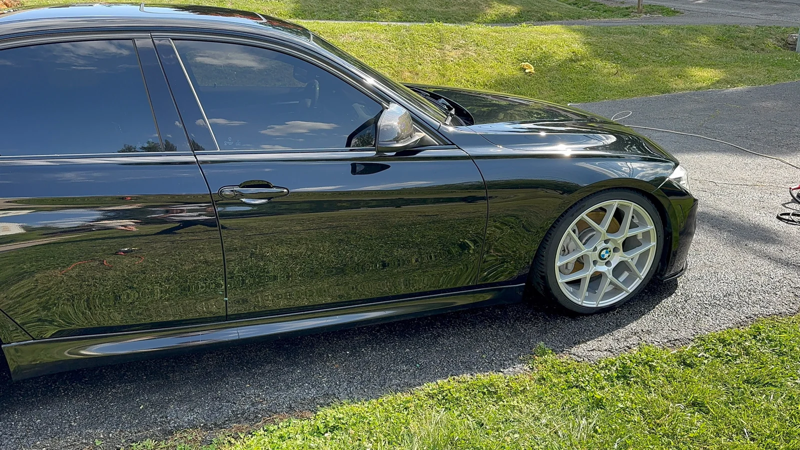 Black BMW side profile with a reflective finish and silver wheels